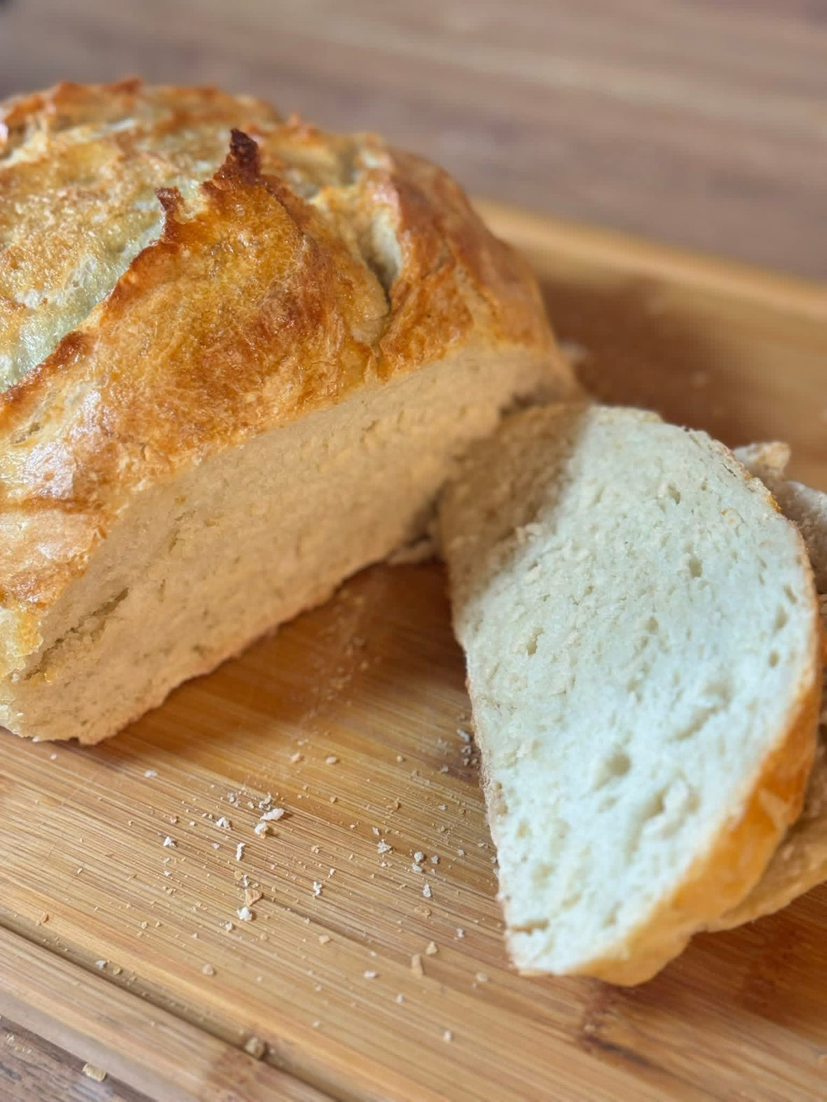 Golden rustic no-knead artisan bread loaf fresh from the oven on a cooling rack